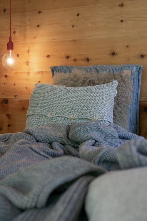 Kissen Grau mit Knöpfen in einem Zirben Holz Schlafzimmer