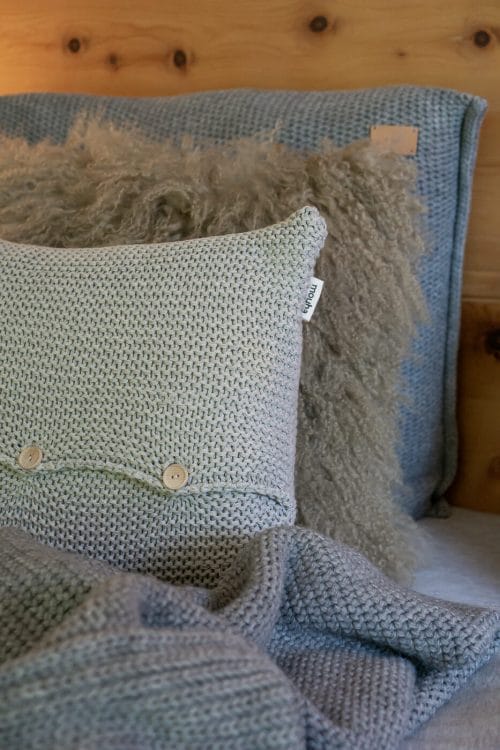 Kissen in Hellgrau mit Holzknöpfen von Moyha für ein gemütliches Bett im Lanhausstil